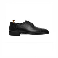 Black cap-toe oxford with brogue detail, side profile