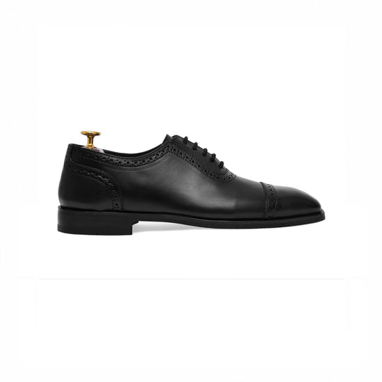 Black cap-toe oxford with brogue detail, side profile
